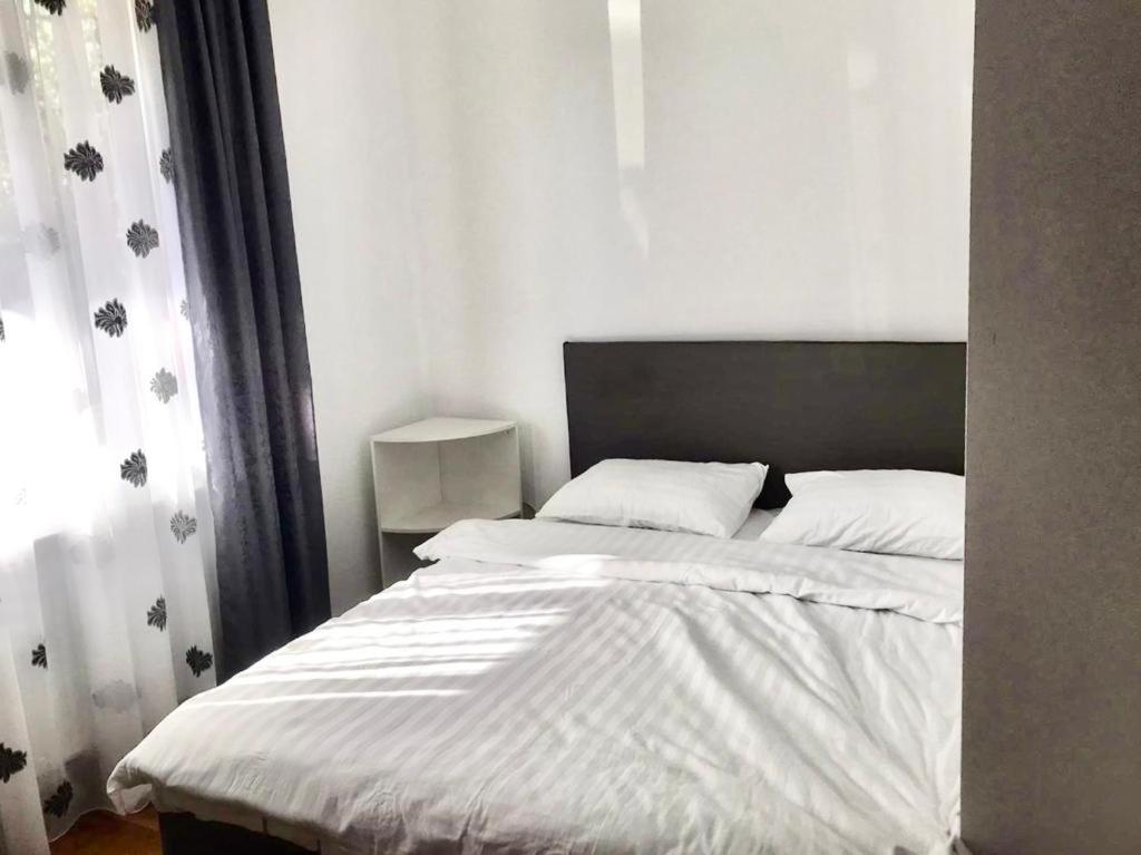 um quarto com uma cama grande e lençóis brancos em Casa Luna em Cluj-Napoca