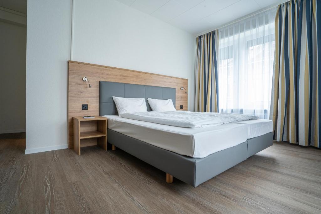 a bedroom with a large bed and a window at Hotel Perron 10 in Winterthur