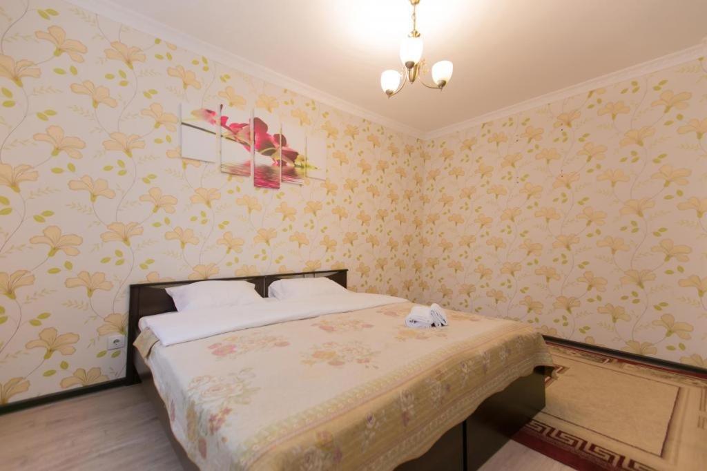een slaapkamer met een bed met geel bloemenbehang bij Warm apartment in Affligem