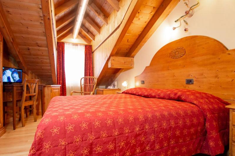 sypialnia z dużym czerwonym łóżkiem w pokoju w obiekcie Locanda Alla Stella w mieście Roana