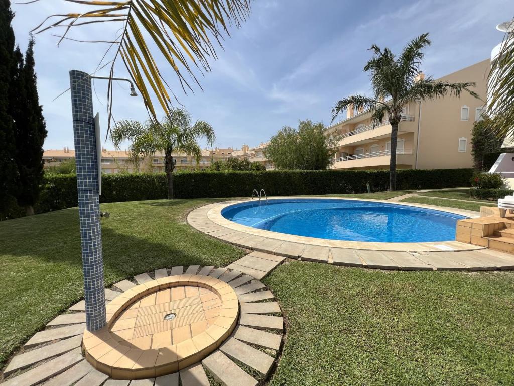 a swimming pool in a yard next to a building at Vilamoura Typical 1 With Pool by Homing in Vilamoura