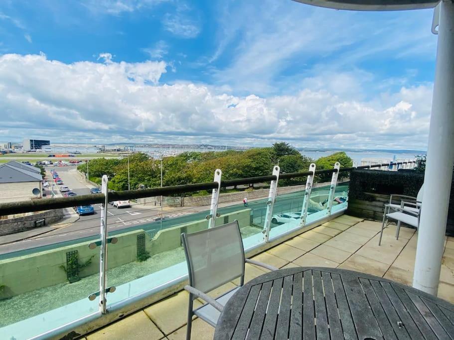 Un balcón con una mesa y vista al agua. en Quayside Apartment - Large and Spacious Duplex, en Castletown