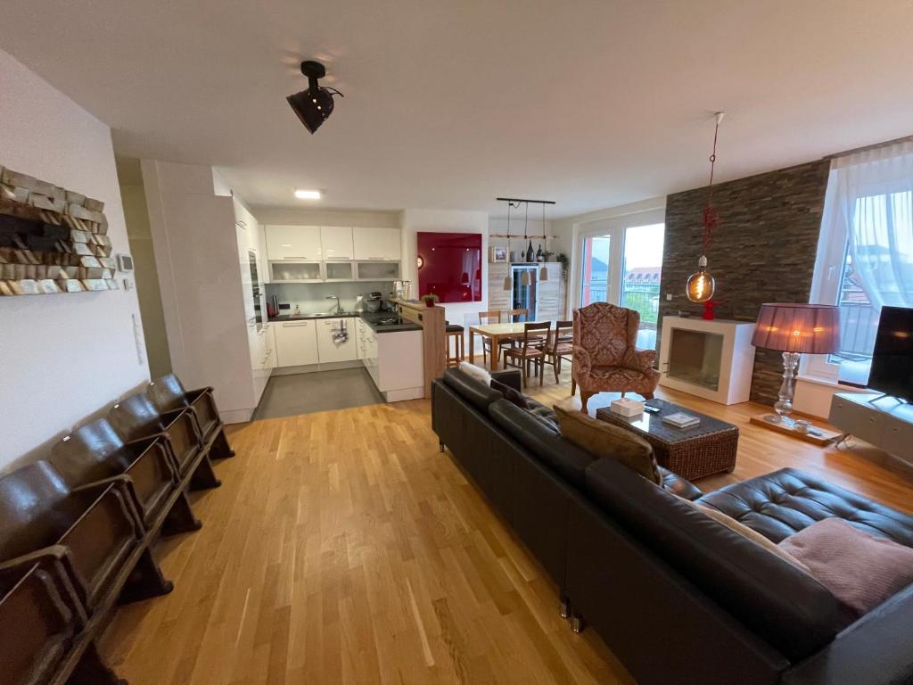 een grote woonkamer met een bank en een keuken bij Penthouse Wohnung am Radweg mit Dachterasse in Waidhofen an der Thaya
