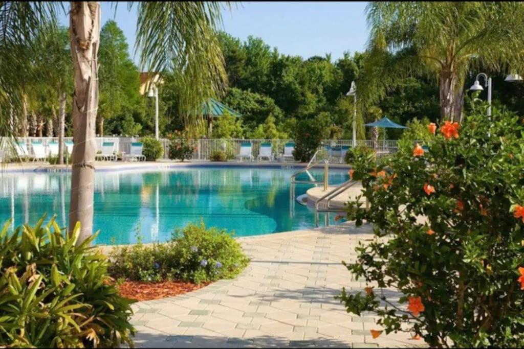 a swimming pool in a resort with trees and plants at Lake view condo close to Disney in Orlando