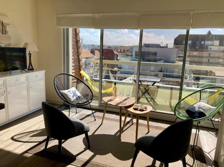 pokój z krzesłami i stołem oraz dużym oknem w obiekcie Studio 53 w mieście Le Touquet-Paris-Plage
