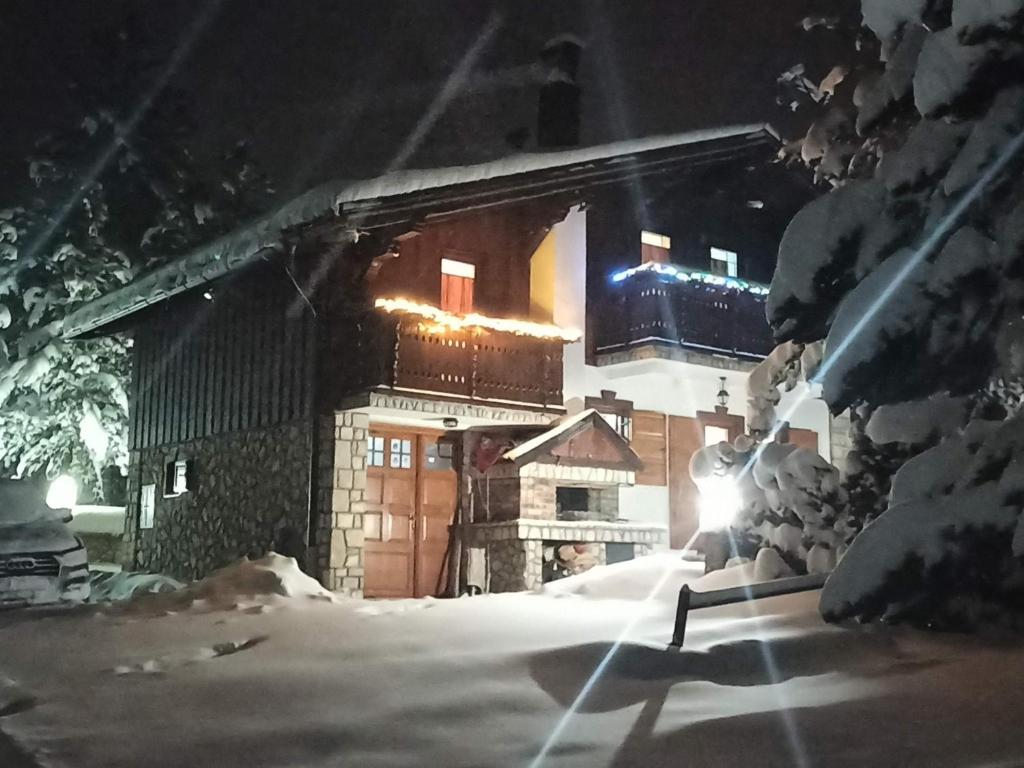 una casa cubierta de nieve por la noche en Vikendica Klara, en Jablanica