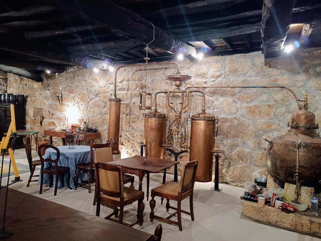 ein Esszimmer mit einem Tisch, Stühlen und einer Steinmauer in der Unterkunft Casario do Vale Hospedagem e Eventos 