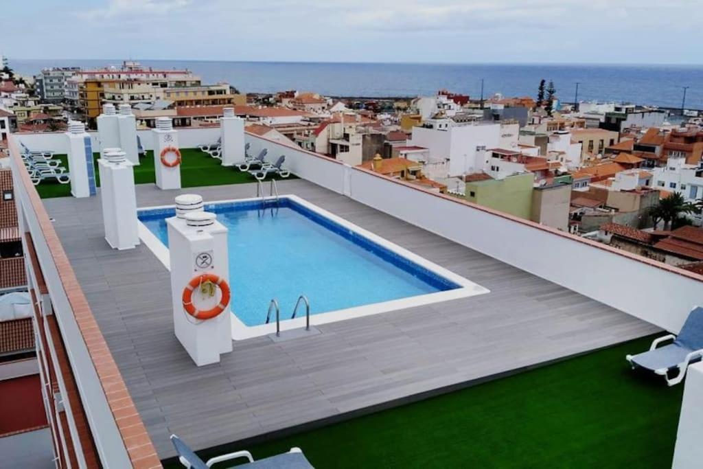 balkon z basenem na dachu budynku w obiekcie Luminoso apartamento en la Plaza del Charco w Puerto de la Cruz