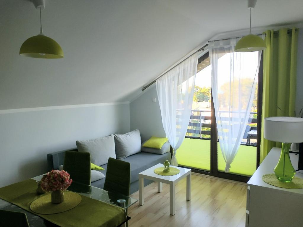 a living room with a couch and a large window at Apartament Limonka in Władysławowo