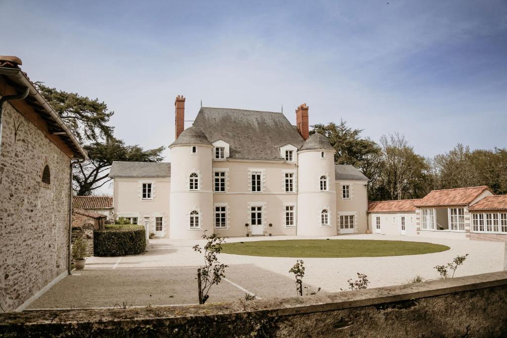 ein großes weißes Haus mit einem großen Hof in der Unterkunft Domaine de La Mazure in La Chapelle-Basse-Mer