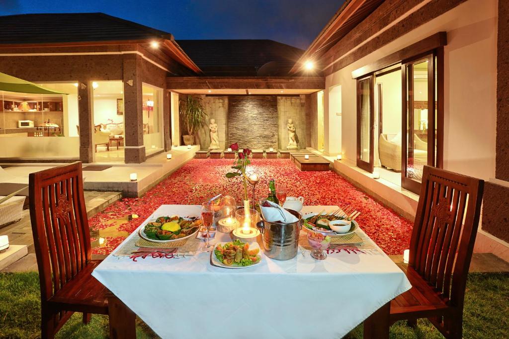 un tavolo con piatti di cibo sopra di The Buah Bali Villas a Seminyak