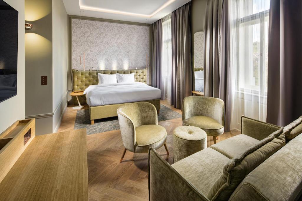 a hotel room with a bed and a couch at Mamaison Hotel Riverside Prague in Prague