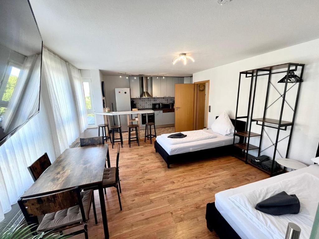 Habitación con 2 camas, mesa y cocina. en Apartment im Stadtzentrum mit W-LAN Home Sweet Home, en Fürth