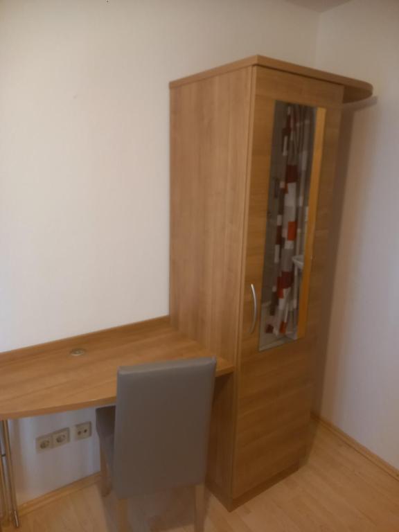 una scrivania in legno con sedia accanto a un armadio di Hotel Krone Bad Cannstatt a Stoccarda