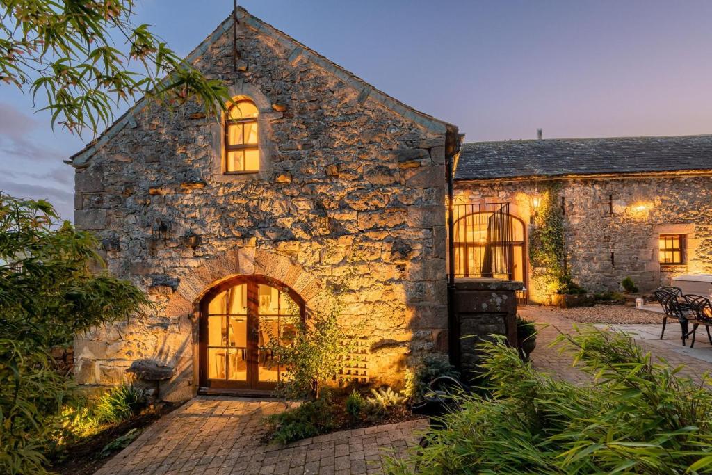 an exterior view of a stone building with windows at Rose Walls in Stainton