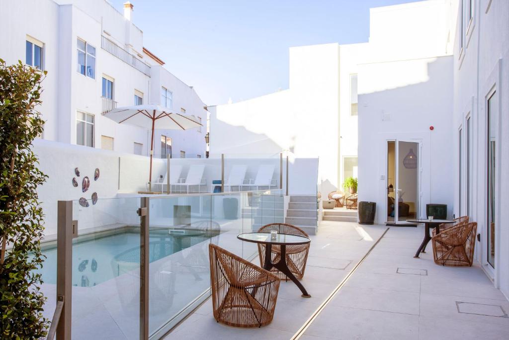 a balcony with a table and chairs and a pool at Casa Margô in Lagos