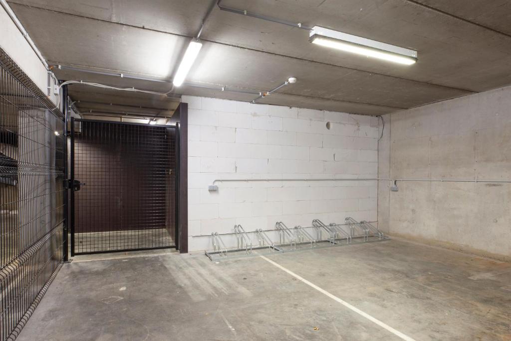 an empty garage with a gate in the wall at Hotel The Lodge Heverlee in Leuven
