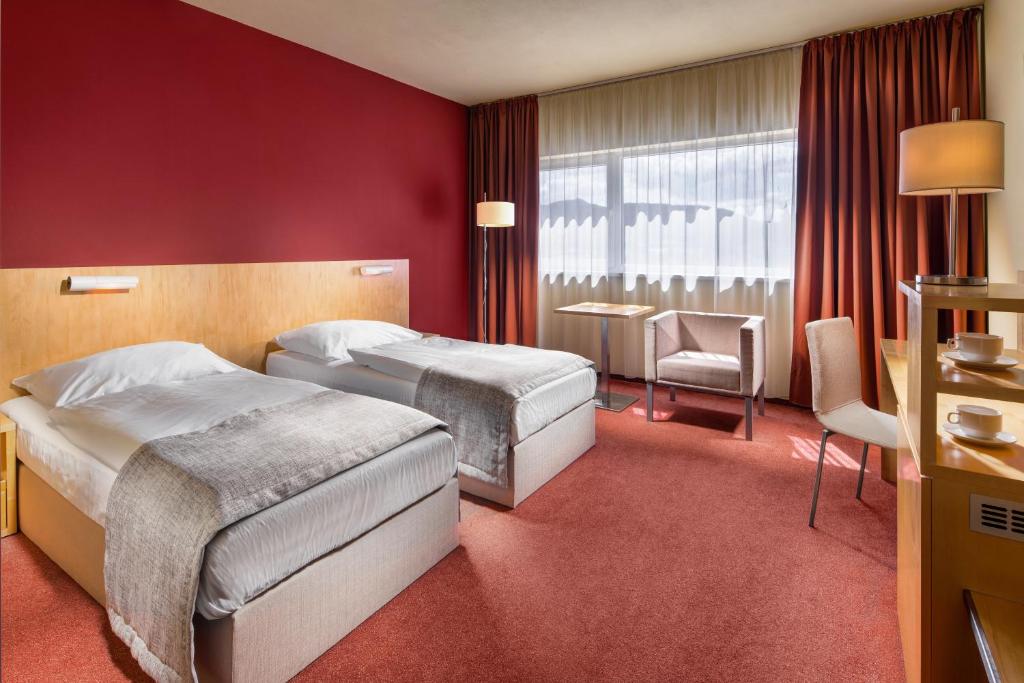 a hotel room with two beds and a window at Clarion Congress Hotel Ústí nad Labem in Ústí nad Labem