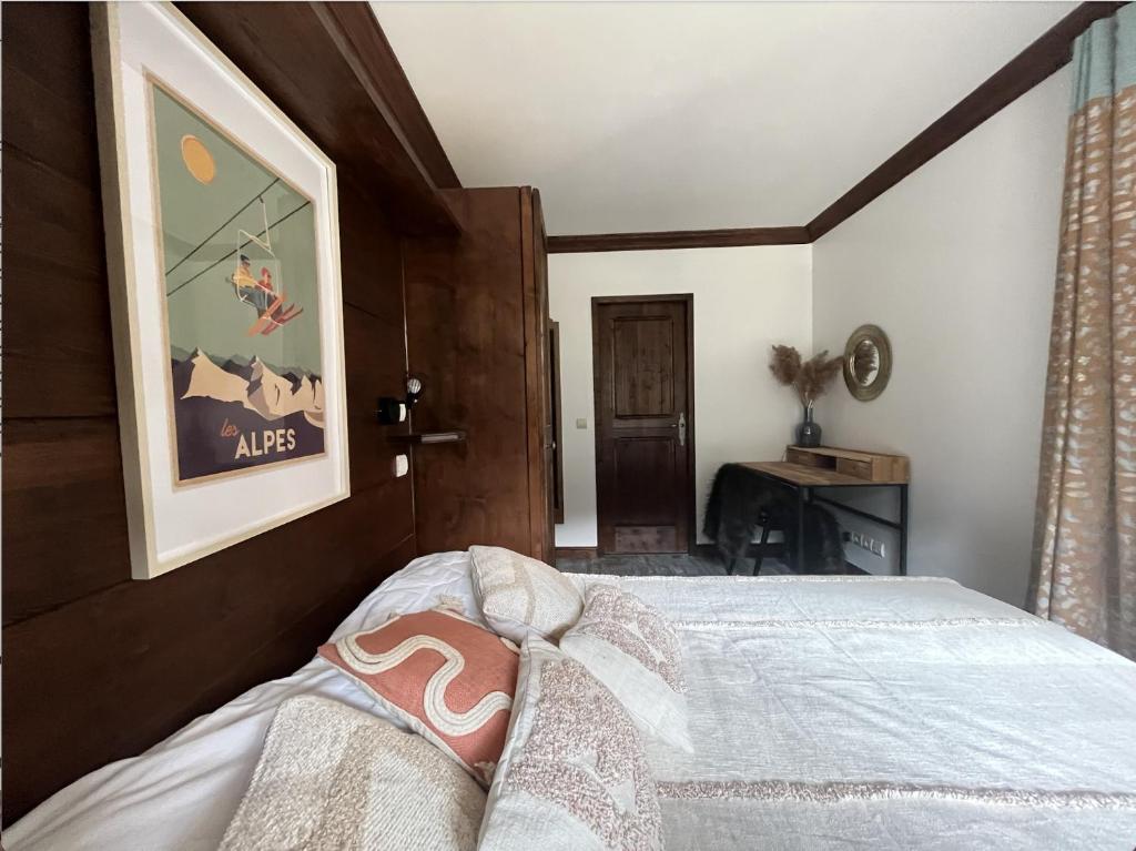 a bedroom with a bed and a picture on the wall at Appartement Manoir de Savoie Arc 1950 in Bourg-Saint-Maurice