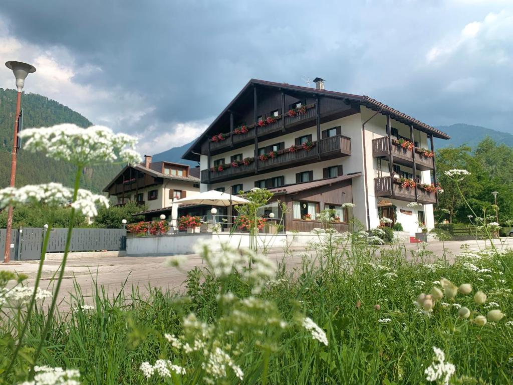 Un bâtiment avec beaucoup de fleurs devant lui dans l'établissement Hotel Ferrari, à Pinzolo