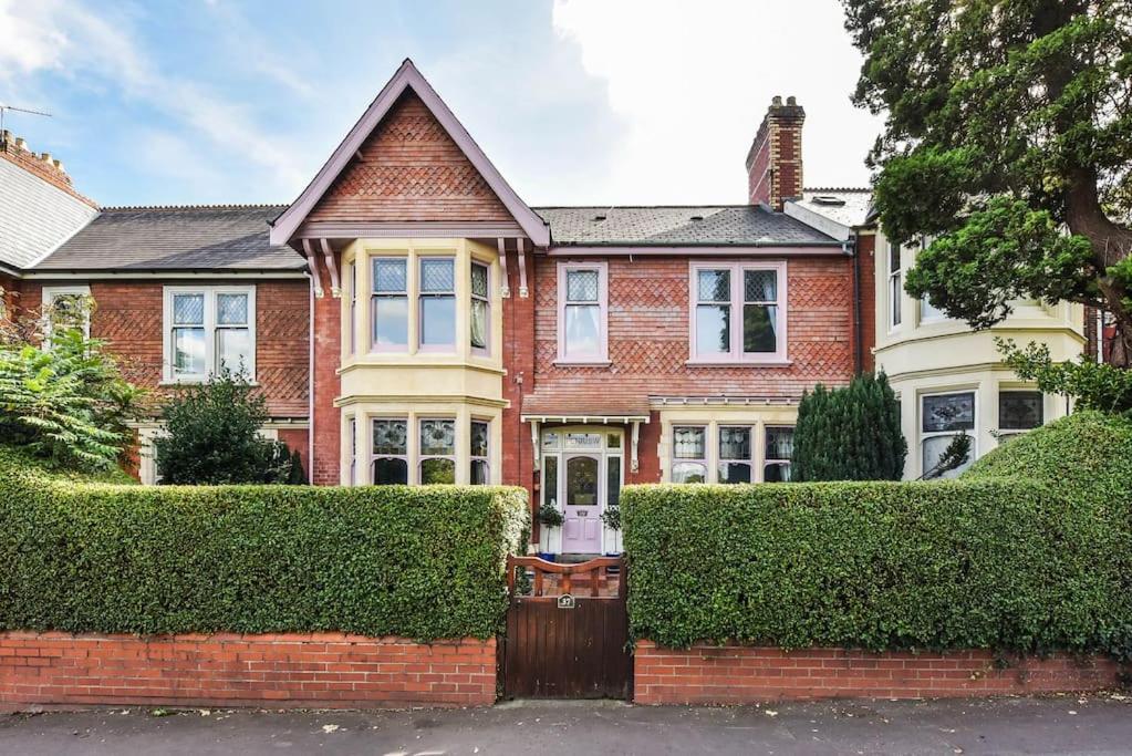 a red brick house with bushes in front of it at Traditional 3-Bed Property in Pontcanna with Parking in Cardiff