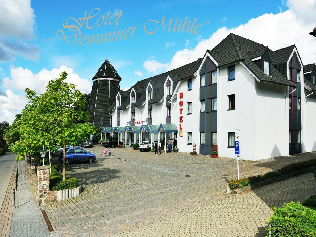 un edificio con un coche aparcado en un aparcamiento en Hotel Demminer Mühle, en Demmin
