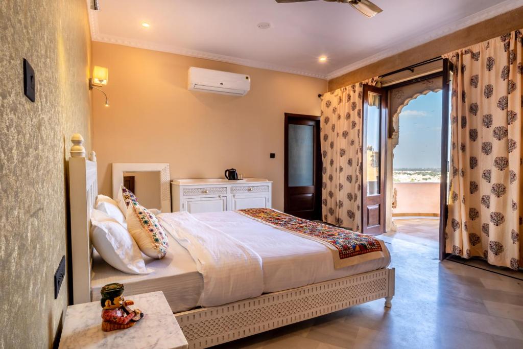 een slaapkamer met een bed en uitzicht op de oceaan bij K D PALACE HOTEL in Jaisalmer