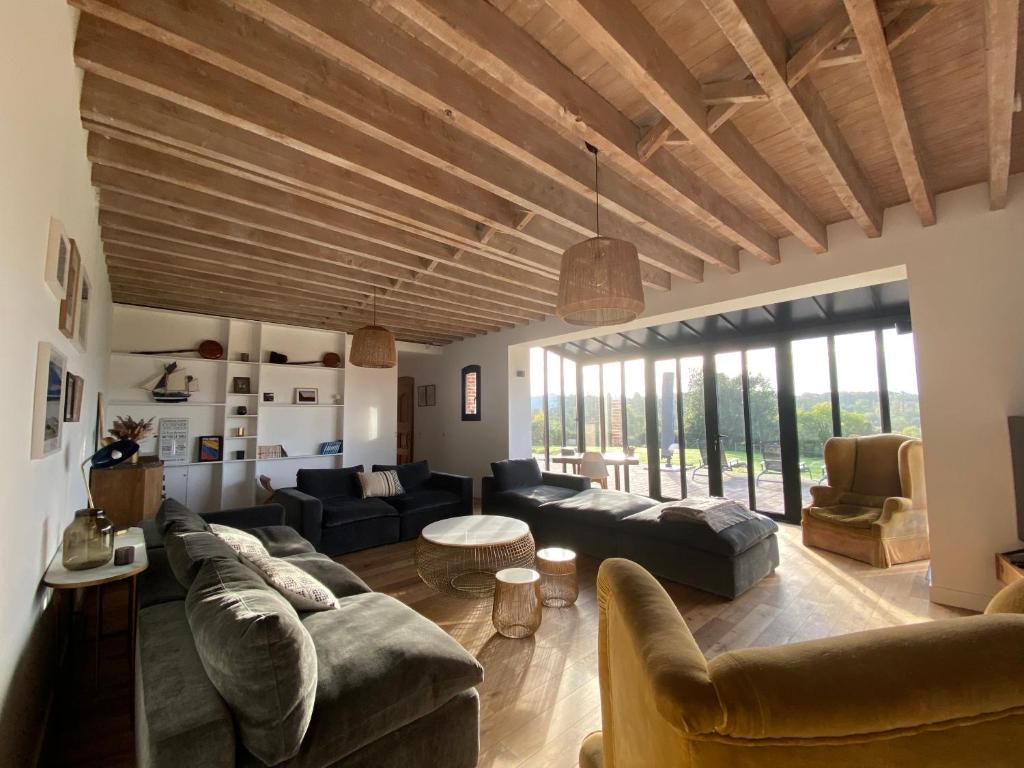 uma grande sala de estar com sofás e uma mesa em L’Etable em Trouville-sur-Mer