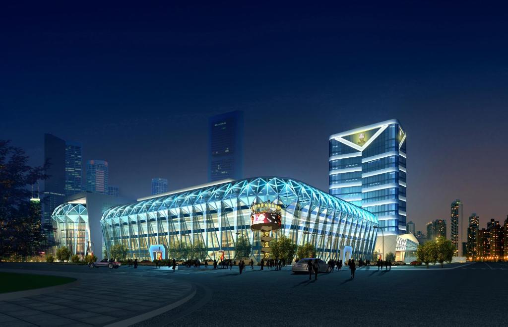 duży szklany budynek w mieście w nocy w obiekcie Shenzhen Baoan PLUS Gems Cube Hotel w mieście Bao'an
