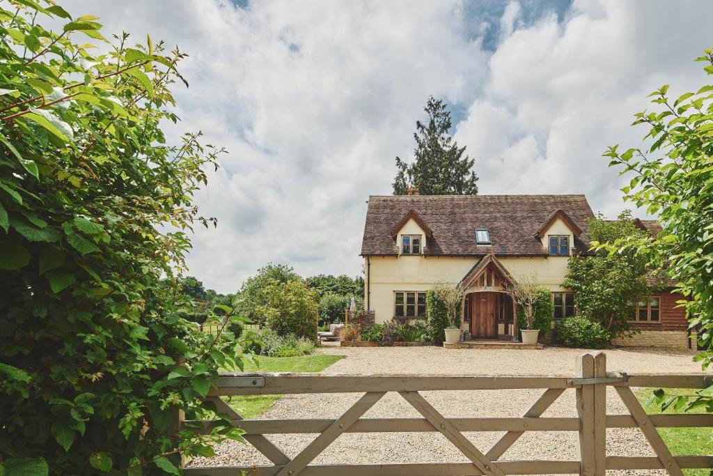 a house with a wooden fence in front of it at Apple Tree Cottage in Beckford