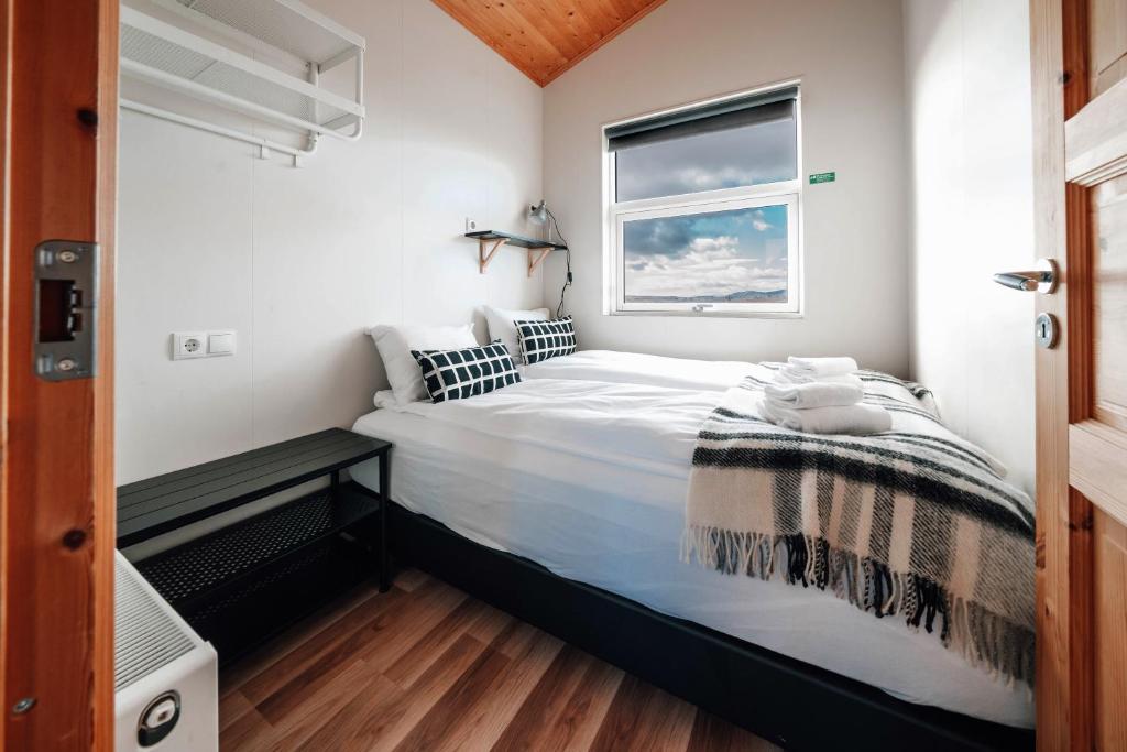a bedroom with a large bed with a window at Blue View Cabin 5B With private hot tub in Reykholt
