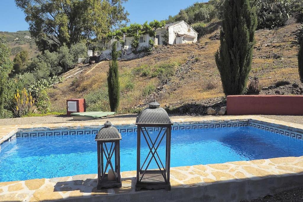 a swimming pool with two lights in front of a house at Cozy House with Private Pool (Lago) in Arenas