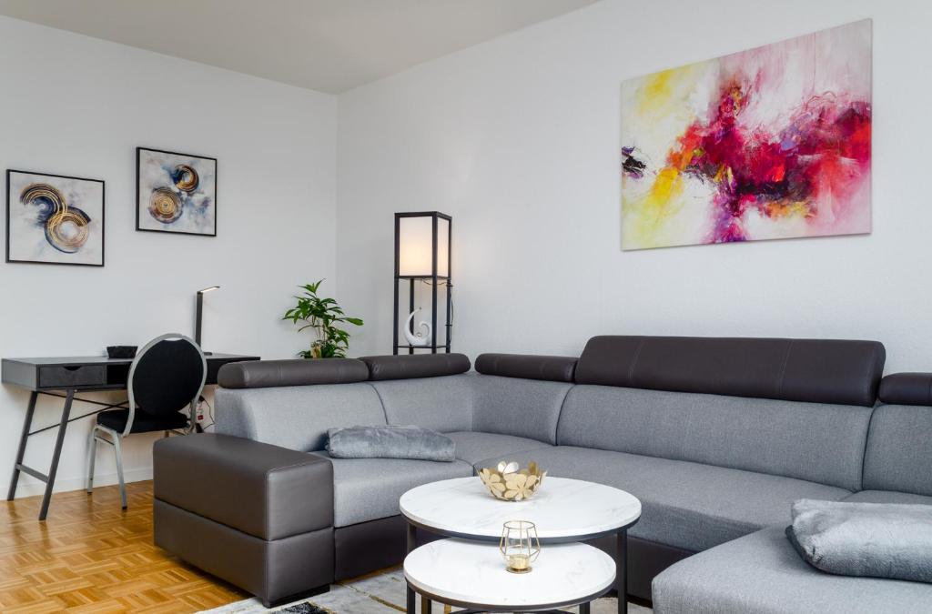 uma sala de estar com um sofá e uma mesa em JeyFL Apartments: Zentral - stilvoll - komfortabel em Magdeburg