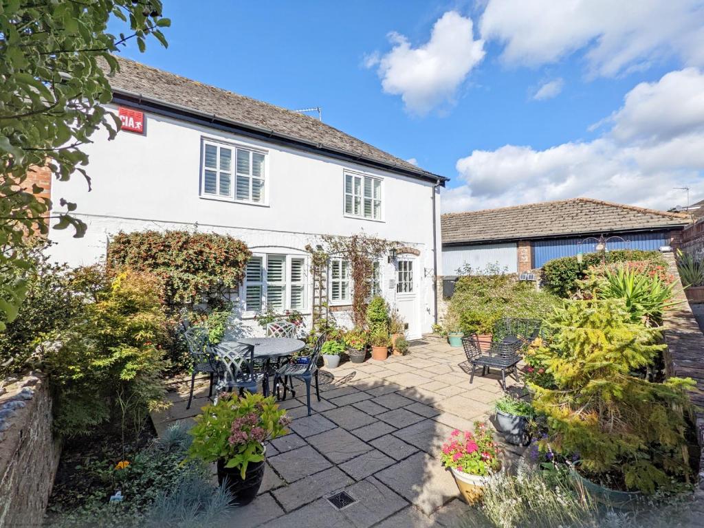 a patio in front of a white house at Baytree Cottage, Walberton in Walberton