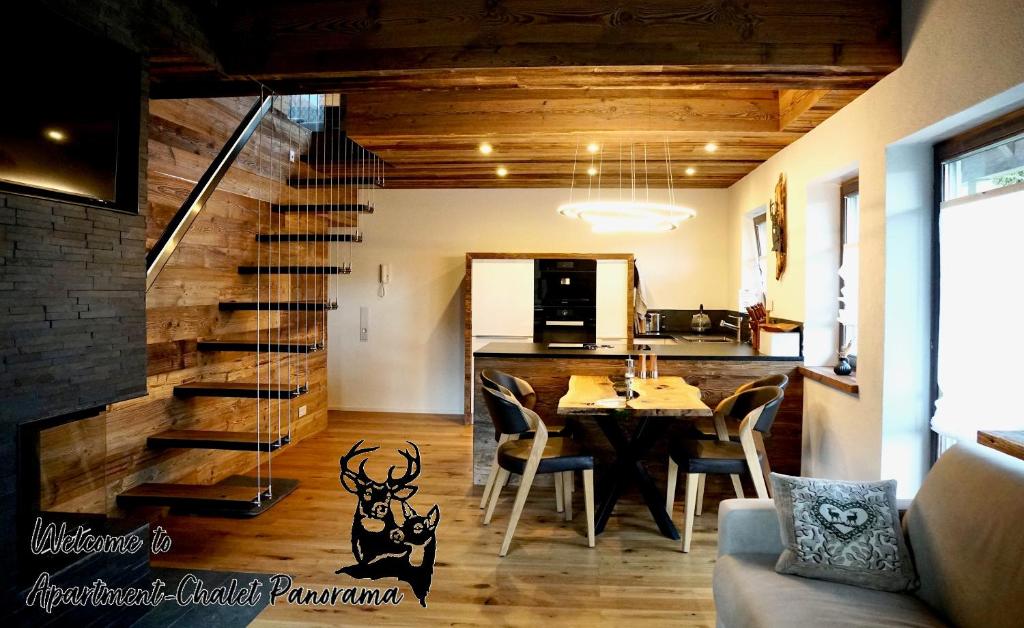 uma sala de jantar e cozinha com uma escada numa casa em Apartment-Chalet Panorama em Todtmoos