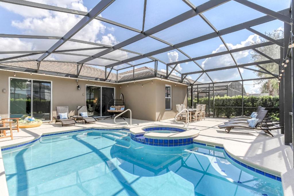 an indoor swimming pool with a glass roof at Oasis at Solterra - 5 bed family resort pool home in Davenport
