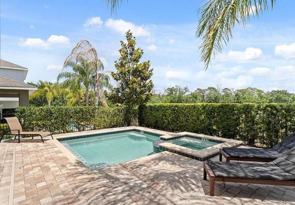 a swimming pool in a yard with two chairs at 371 P Luxury Villa- New Listing in Orlando