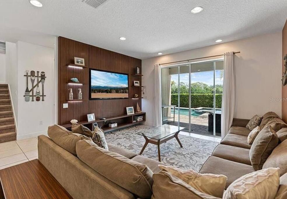 a living room with a large couch and a tv at 371 P Luxury Villa- New Listing in Orlando