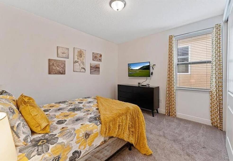 a bedroom with a bed and a flat screen tv at 371 P Luxury Villa- New Listing in Orlando