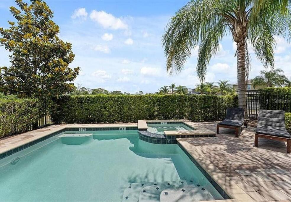 a swimming pool with two chairs and a palm tree at 371 P Luxury Villa- New Listing in Orlando