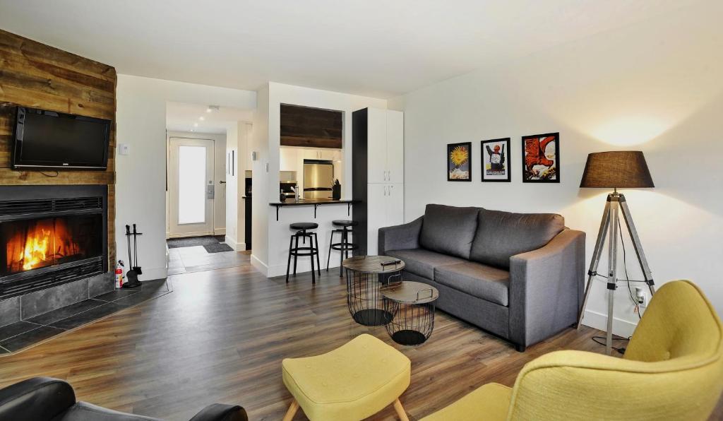 a living room with a couch and a fireplace at Hameau 24#22 - Studio in Stoneham