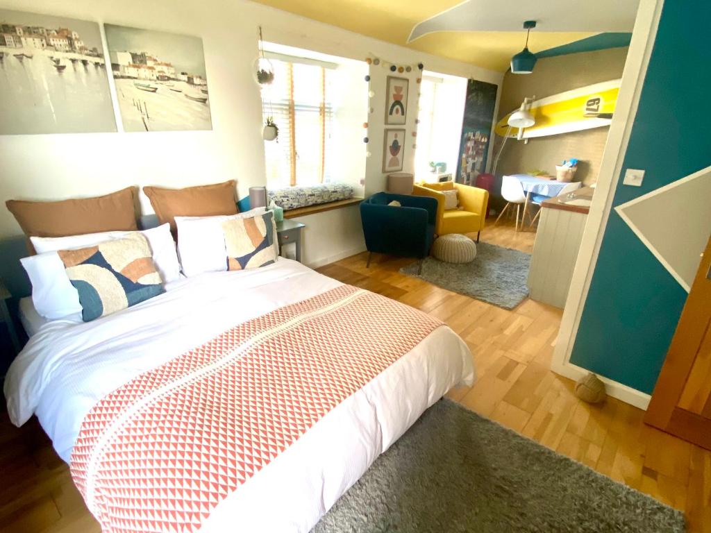 um quarto com uma cama e uma sala de estar em St Ives Balcony Flat em St Ives