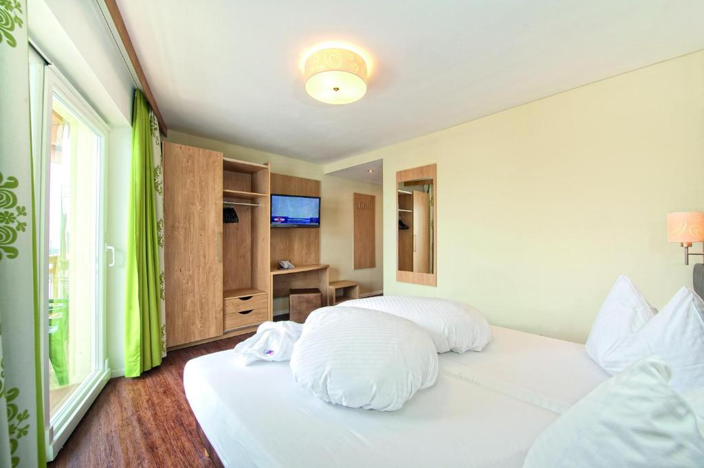 Ένα ή περισσότερα κρεβάτια σε δωμάτιο στο Hotel ALPINA