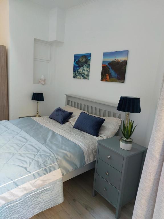 1 dormitorio con 1 cama, mesita de noche y 2 lámparas en Seaside Apartment with Seaview in Dublin 3 close to city centre, en Dublín