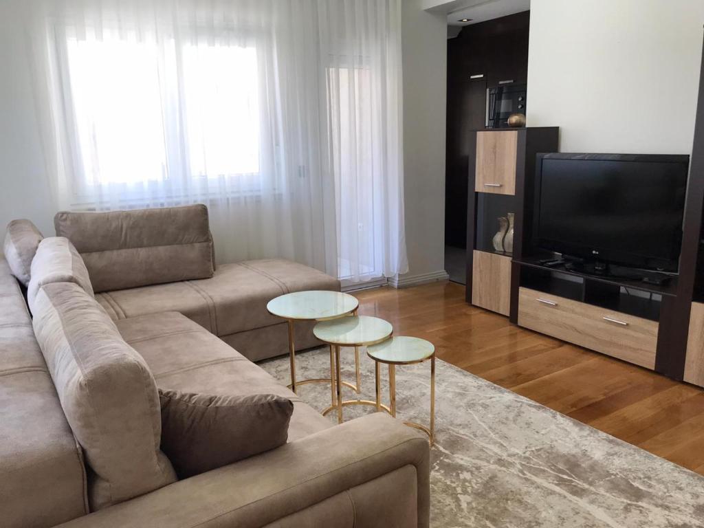 sala de estar con sofá y 2 mesas en Paradiso Apartment en Novi Pazar