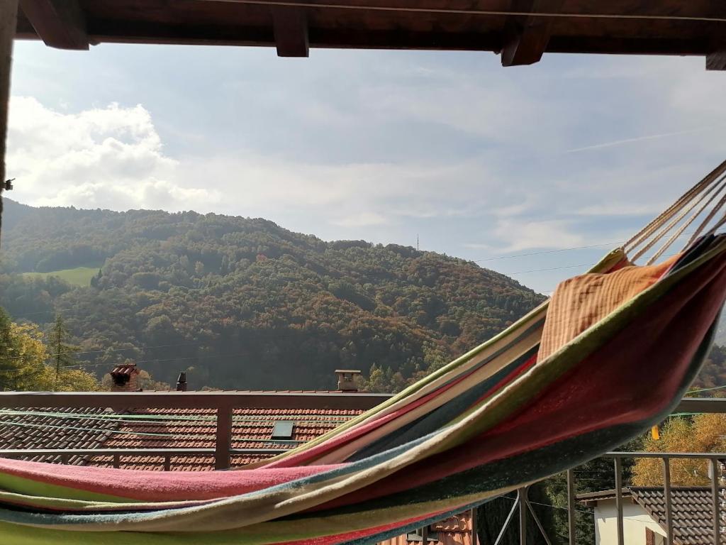 a hammock on a balcony with a mountain in the background at Nandagon Gasthouse 