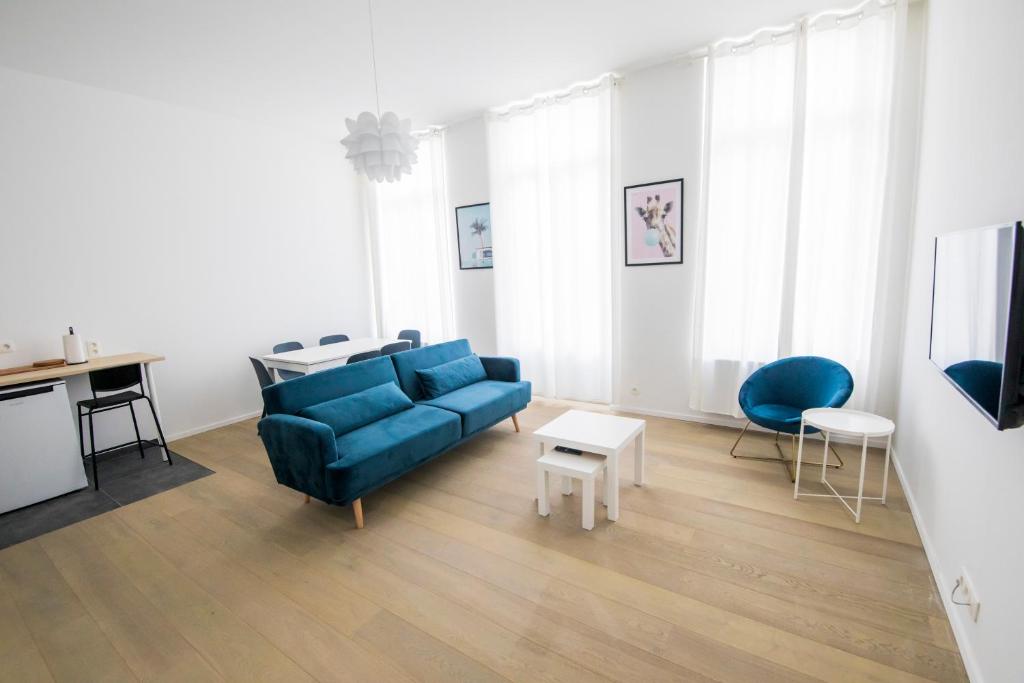 a living room with a blue couch and a table at Smart Appart - Clmenceau in Brussels