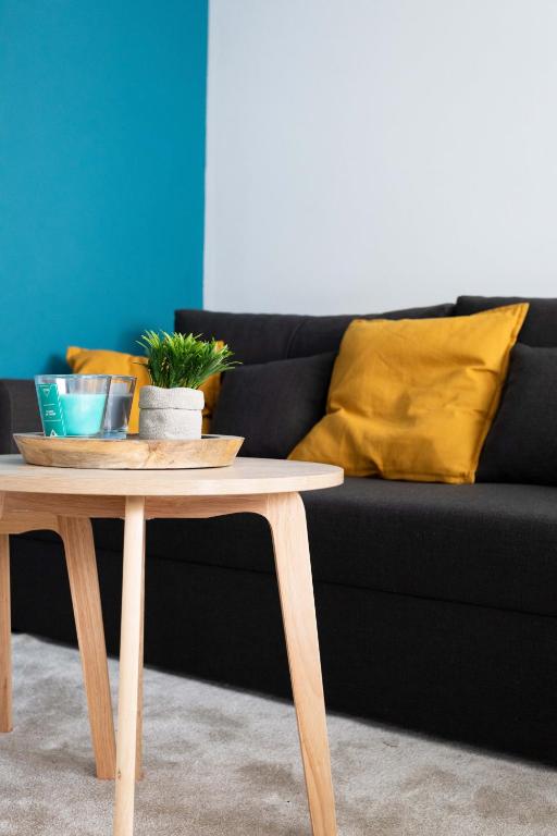 - une table basse en face d'un canapé noir dans l'établissement Au COEUR du STADE DE FRANCE, à Saint-Denis