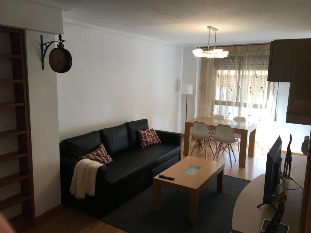 uma sala de estar com um sofá preto e uma mesa em Apartamento Calle Turco 13 em Zaragoza