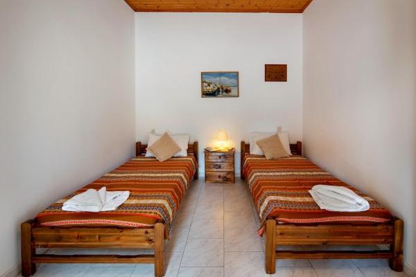 two twin beds in a room with at Alekos House in Longós